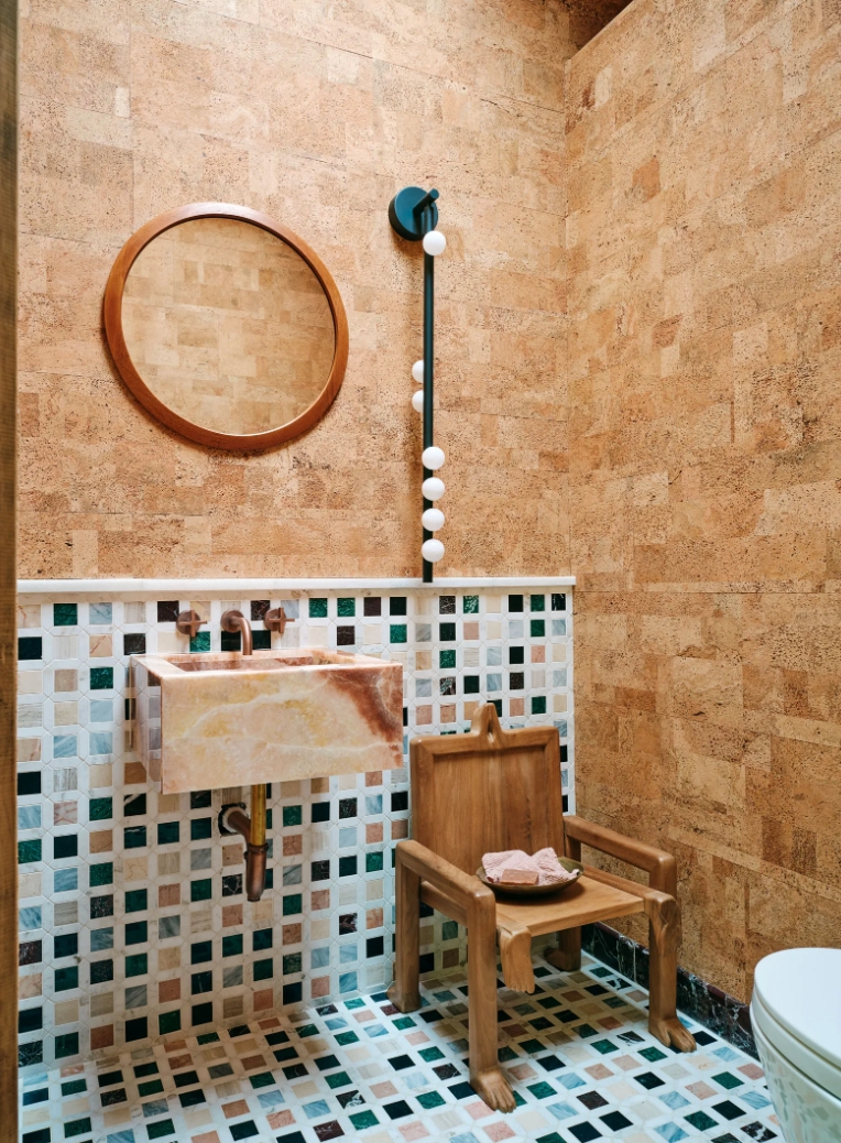 Tiled Bathroom with Mirror, Marble Sink, and Low Wooden Chair