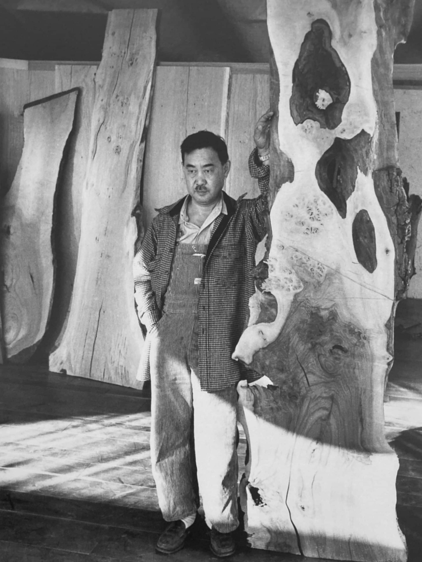 George Nakashima is pictured sometime in the 1950s with one of his signature wood slabs, recently sold